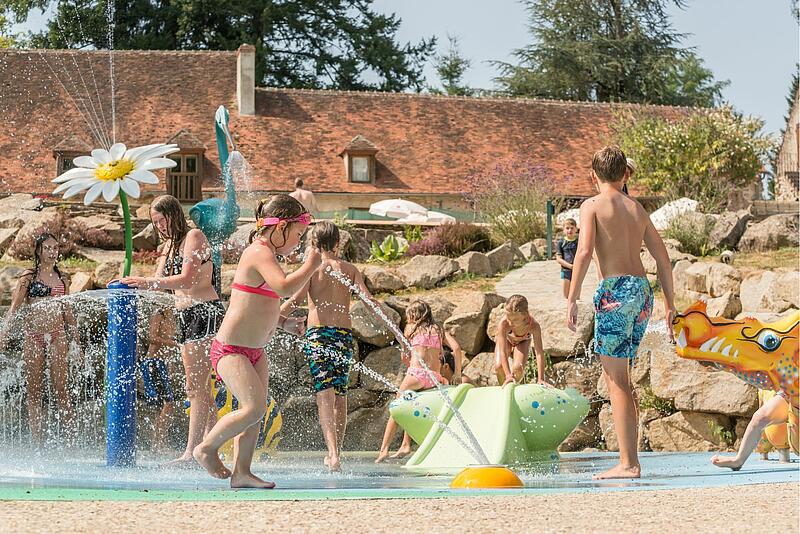 des familles qui jouent dans l'espace aquatique d'un camping de luxe