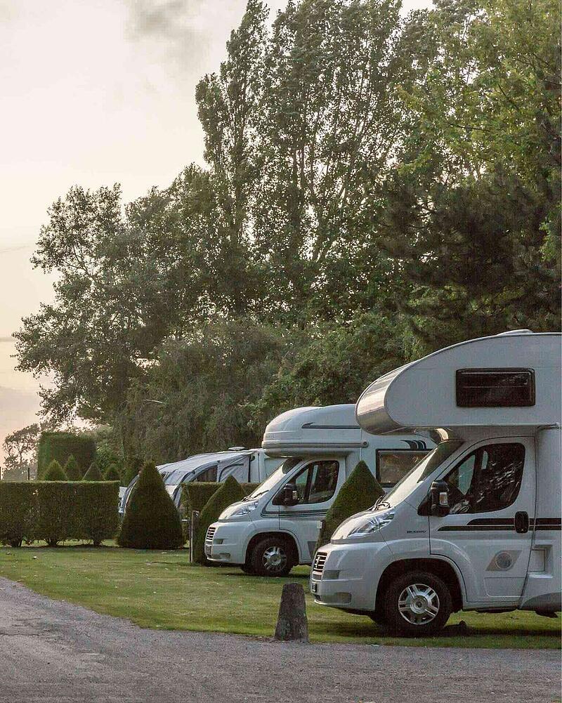Spacious, hedged motorhome pitches at a Les Castels campsite near Calais, designed for easy access for caravans and campers catching a ferry.