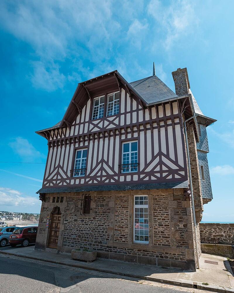 A beautiful historic building combining a stone ground floor with upper levels featuring traditional half-timbered architecture, discovered while staying at Les Castels.