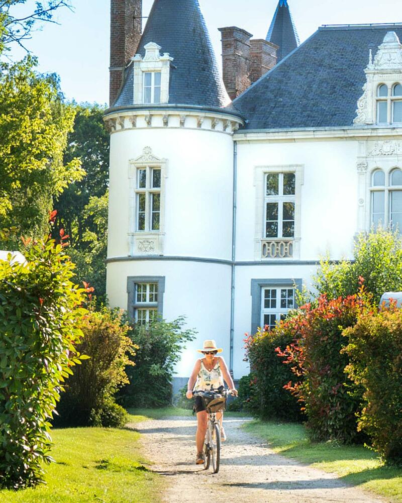 A person cycling along a winding path through a park, illustrating the leisure activities available on a last-minute cycling holiday at Les Castels in France