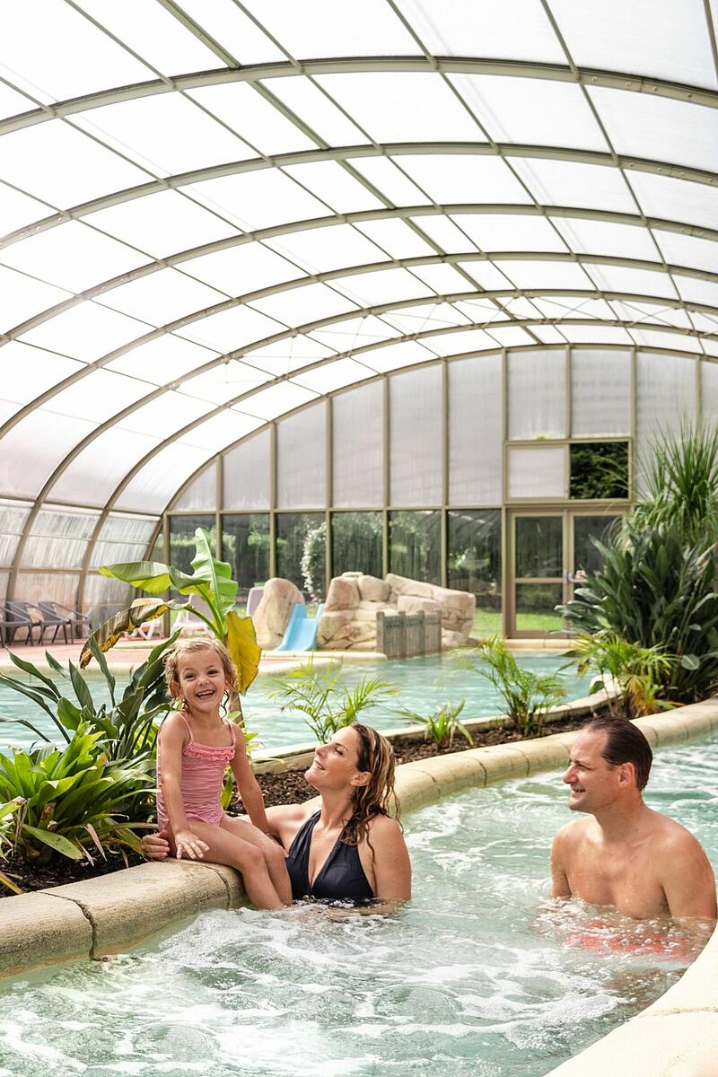 Espace aquatique au camping du Domaine de la Ville Huchet Une famille profite du parc aquatique de la Ville Huchet, camping de luxe à Saint-Malo